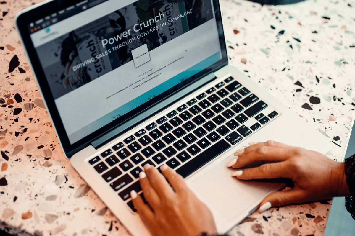 Hands typing on laptop with a digital marketing case study on screen.